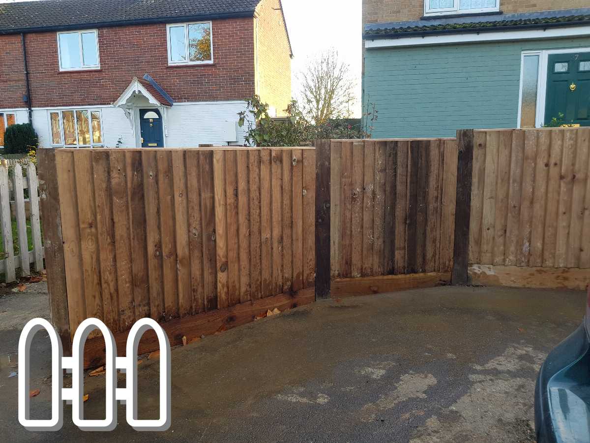 Newly installed wooden fence panels in residential driveway, displaying robust and natural wood construction against a backdrop of suburban homes.