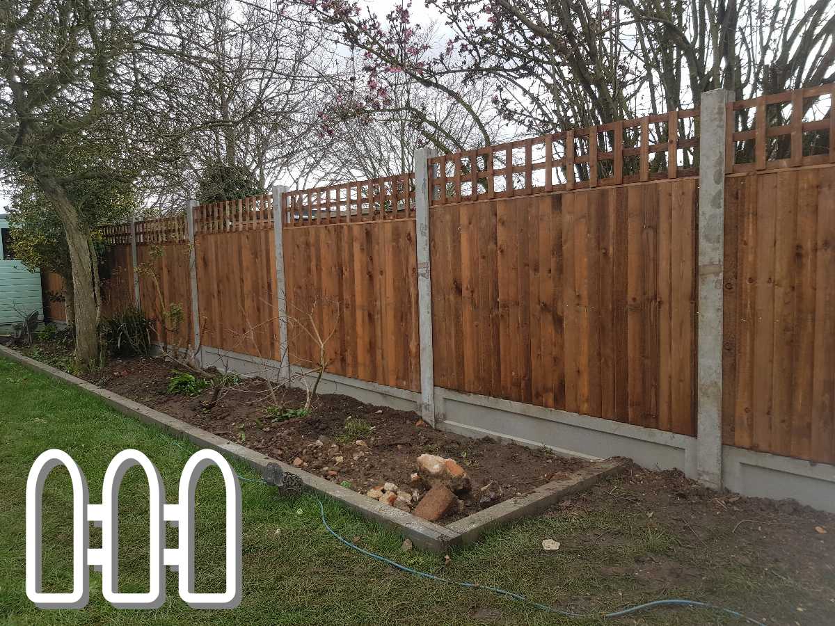 New wooden fence with lattice top installed in a residential backyard, featuring green lawn and budding trees, enhancing the property's privacy and aesthetic appeal.
