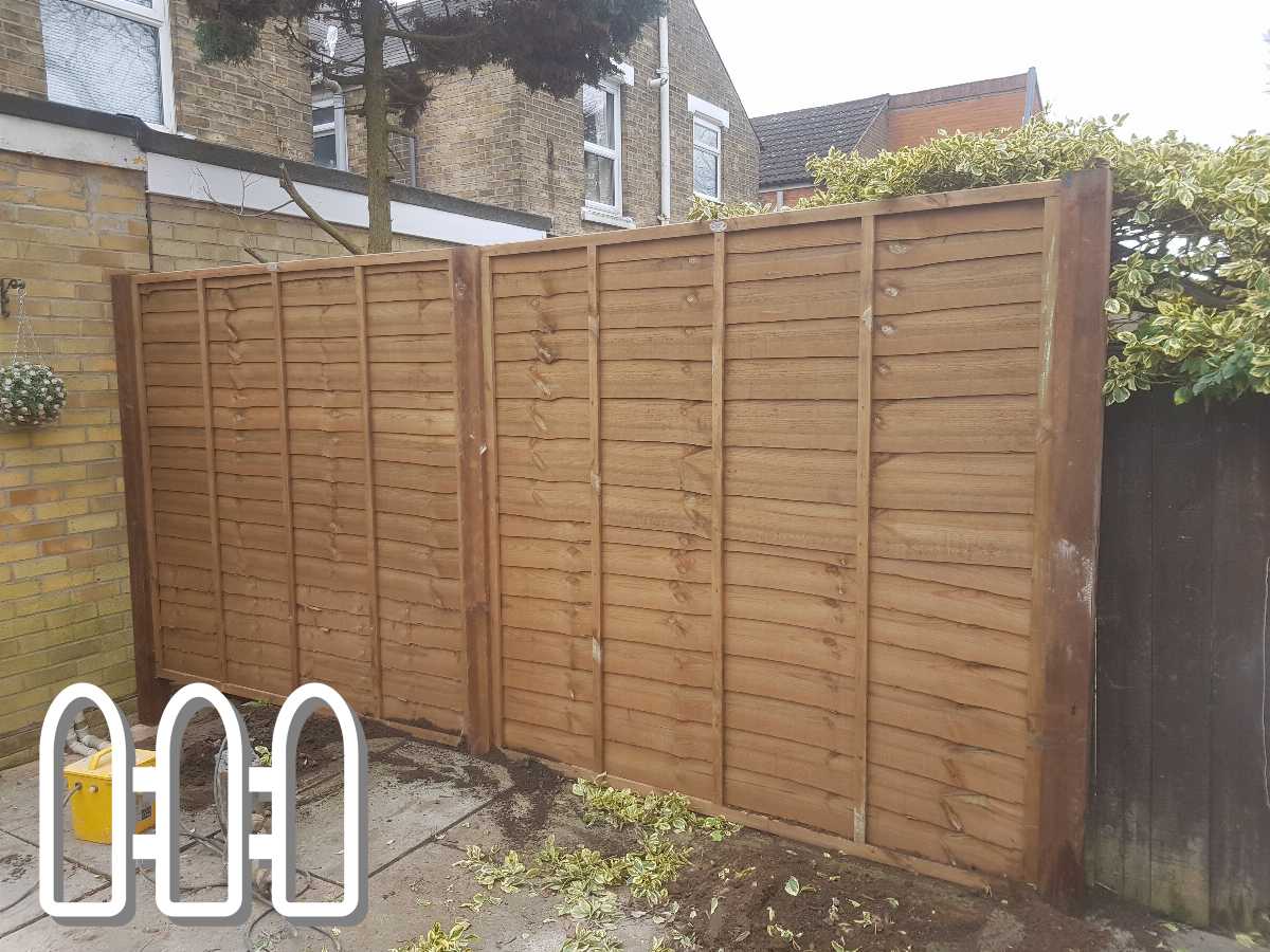 Newly installed wooden fence by Fencing Colchester with garden tools visible, enhancing backyard privacy and security