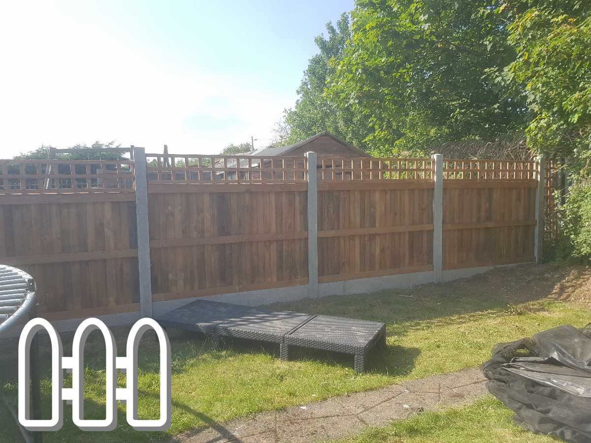 A newly installed wooden fence with lattice top panels in a residential backyard, showcasing sturdy posts and a well-maintained grassy area.