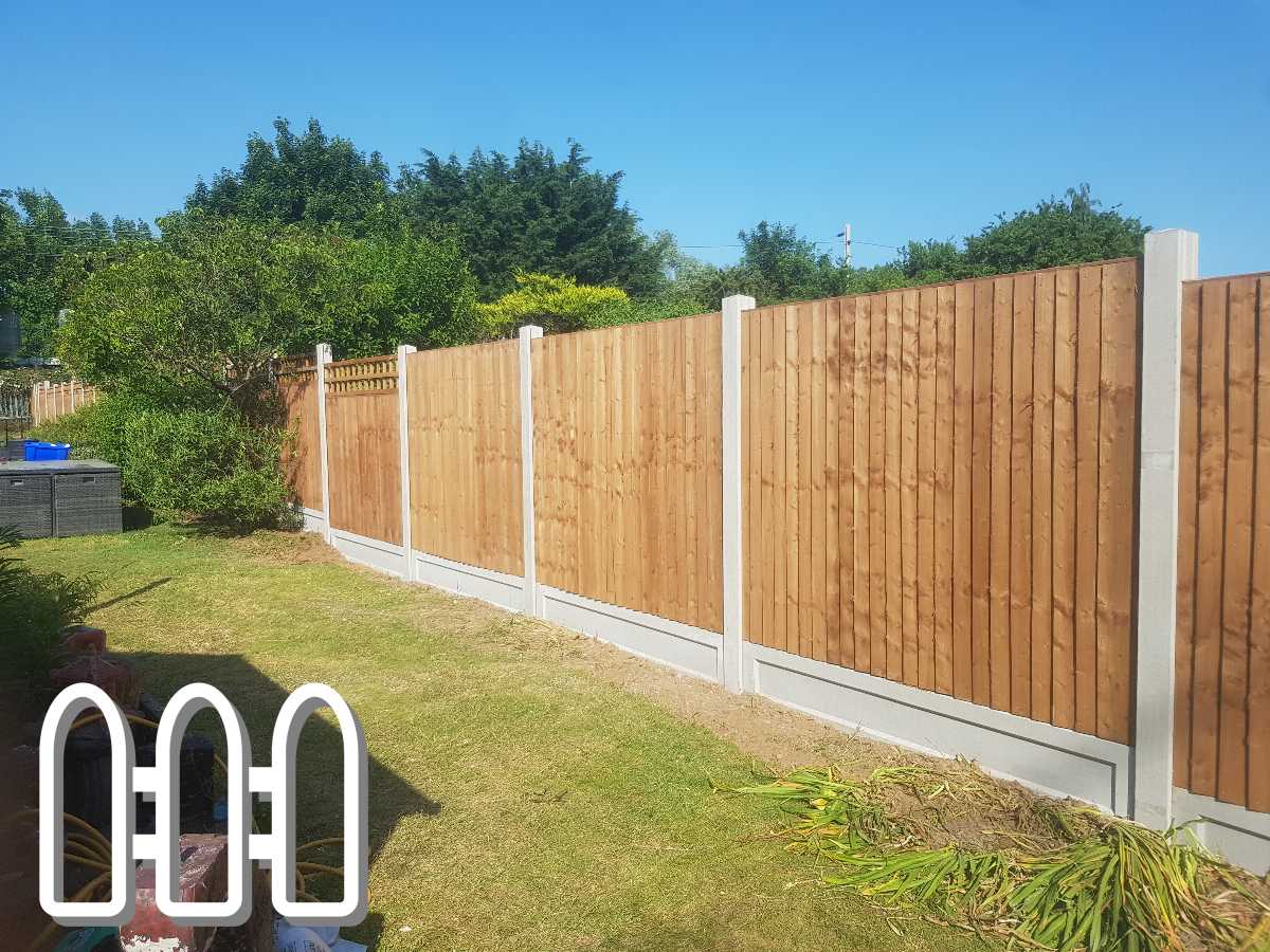 Newly installed wooden fence with concrete posts and gravel boards in a sunny garden, featuring lush greenery in the background