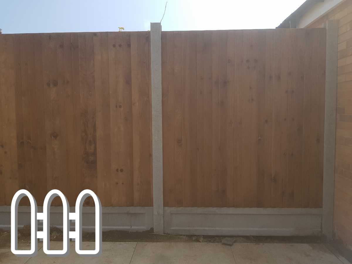 Newly installed wooden fence panels between concrete posts and gravel boards beside a brick house