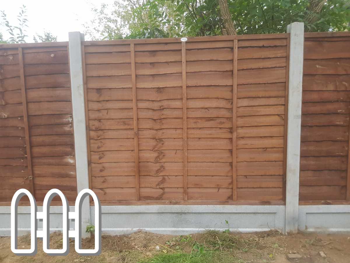 A sturdy wooden fence with concrete supports installed in a garden area, demonstrating a modern and secure residential fencing solution
