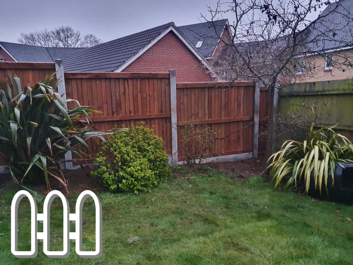 A well-maintained garden featuring a vibrant green lawn and various shrubs with a sturdy wooden fence in the background, under an overcast sky.