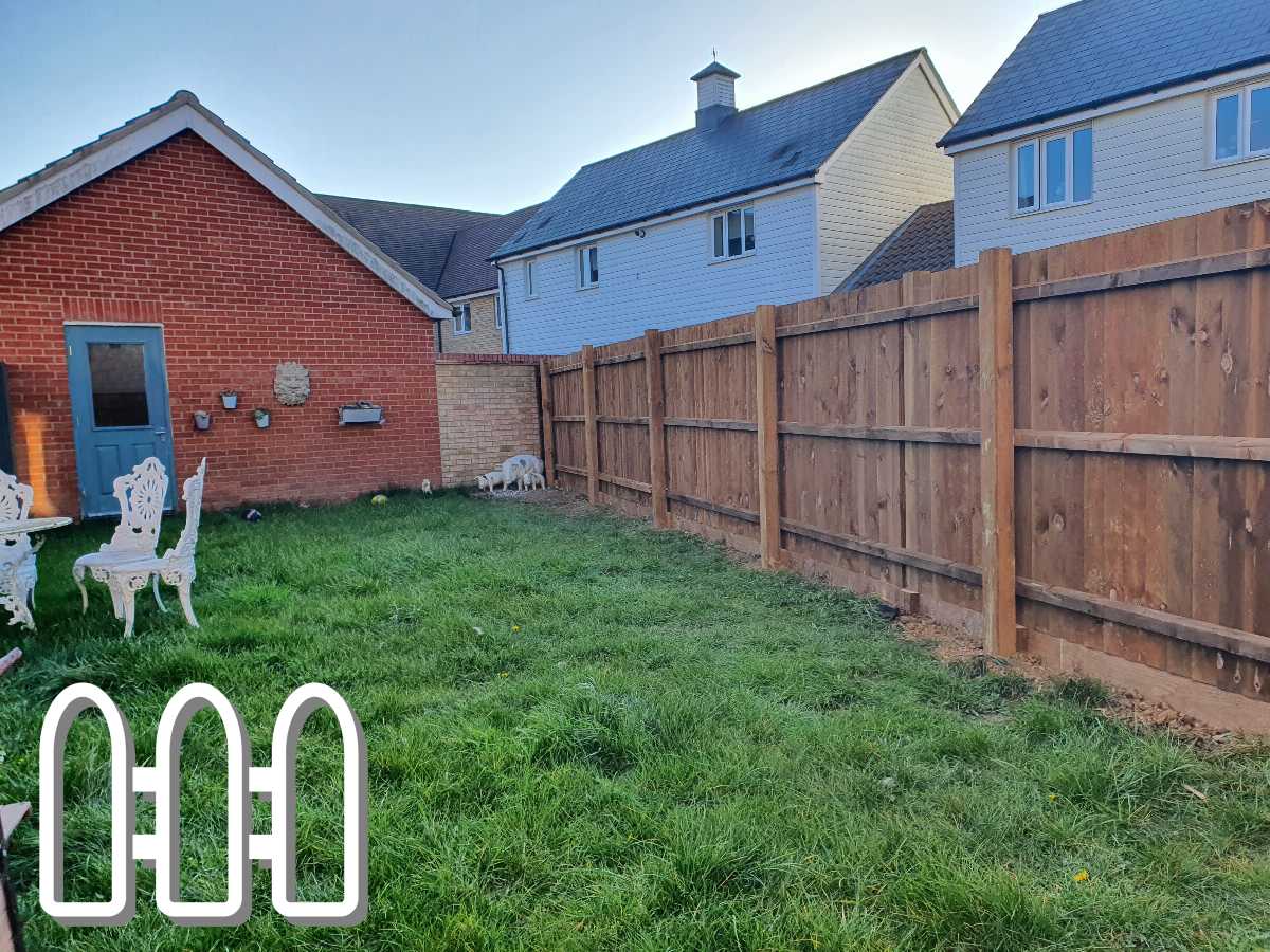 Residential backyard with a new wooden fencing installed alongside lush green lawn, vintage metal chairs, and a quaint red brick house with a blue door.