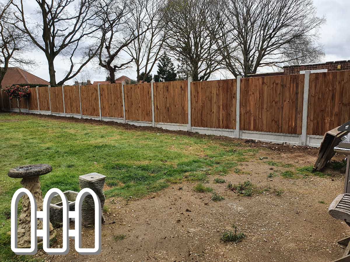 Newly installed wooden fence with concrete posts in a backyard garden, featuring grassy lawn and decorative stone bird bath and basket