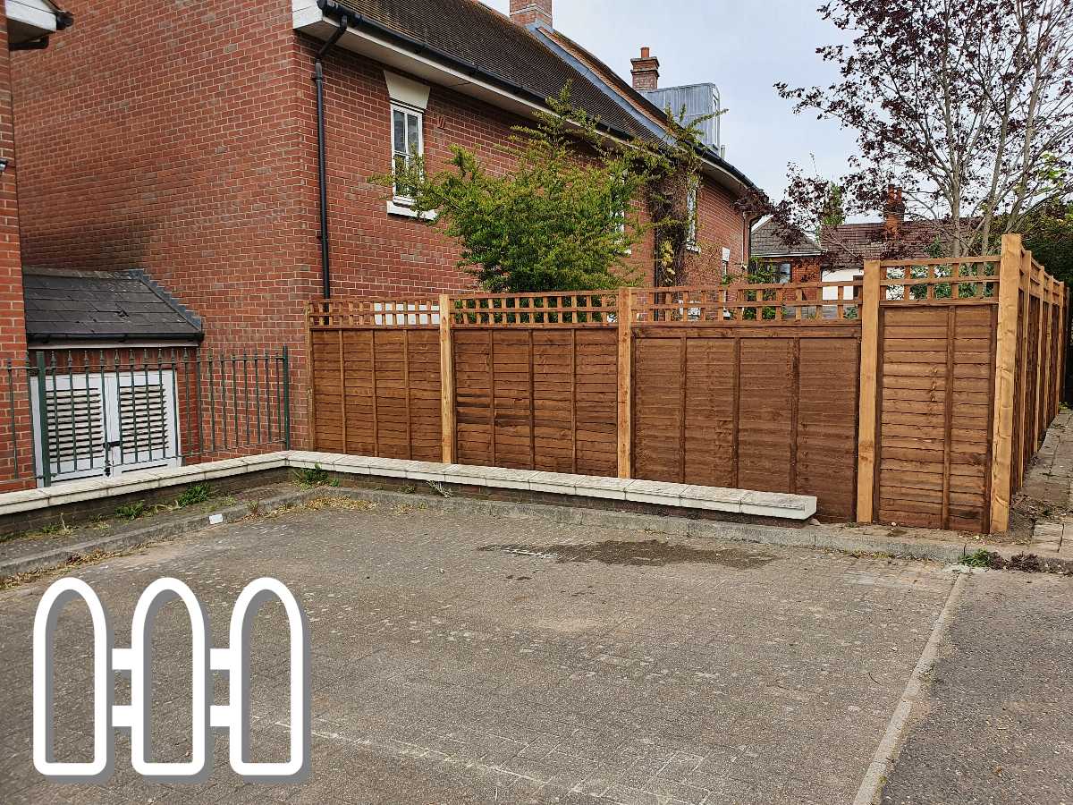 New wooden fence installation in urban parking area with brick buildings in the background