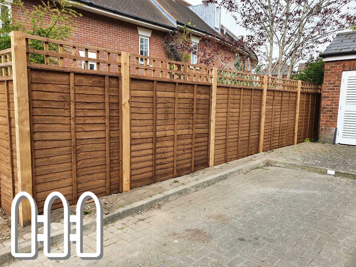 Newly installed wooden fence with vertical panels and lattice top alongside a driveway in a suburban area
