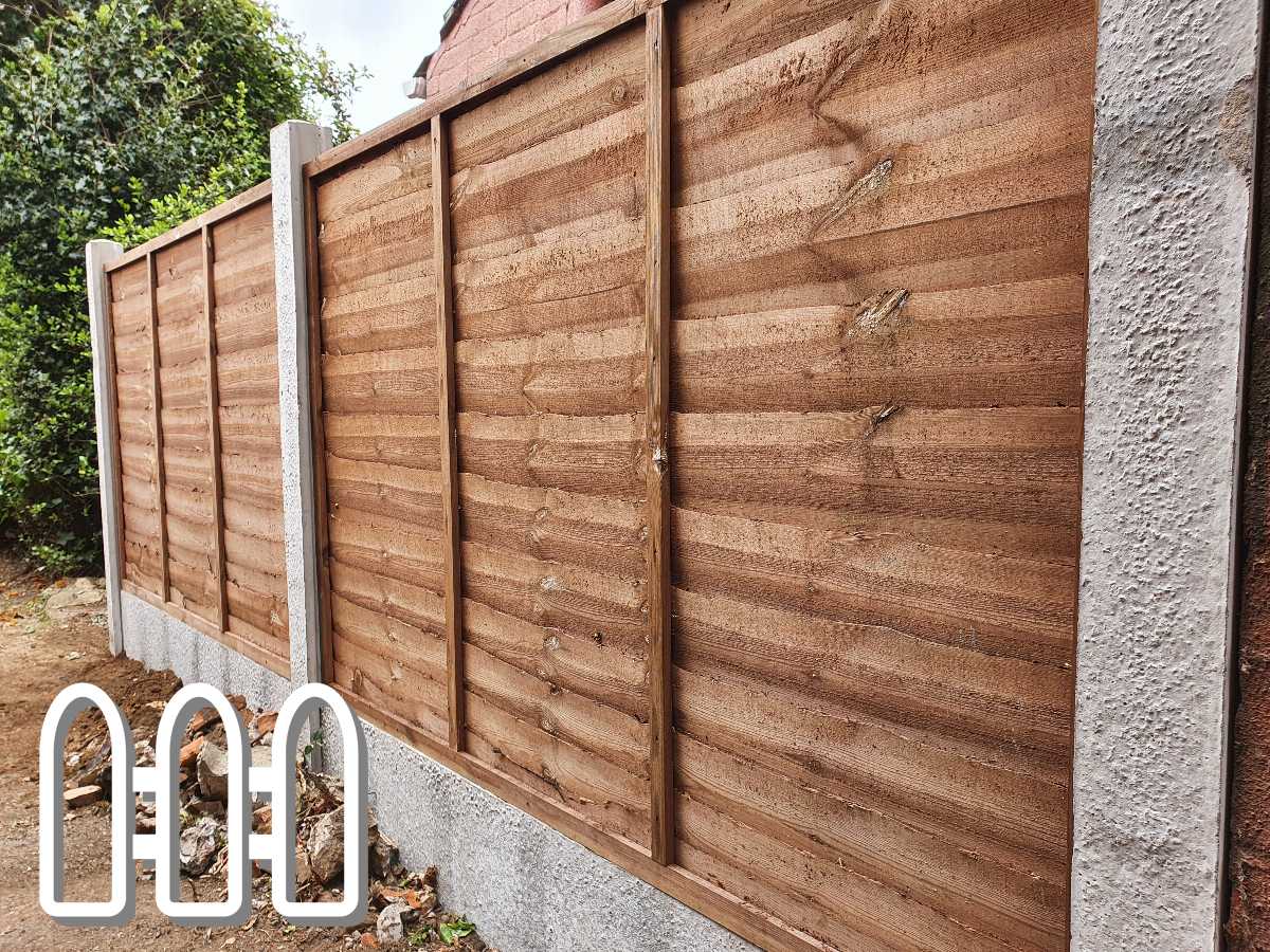 Sturdy wooden fence panels installed with concrete posts on a residential property, featuring visible damage and wear